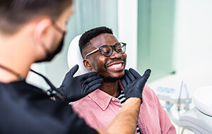 Dentist looking at smiling patient's teeth